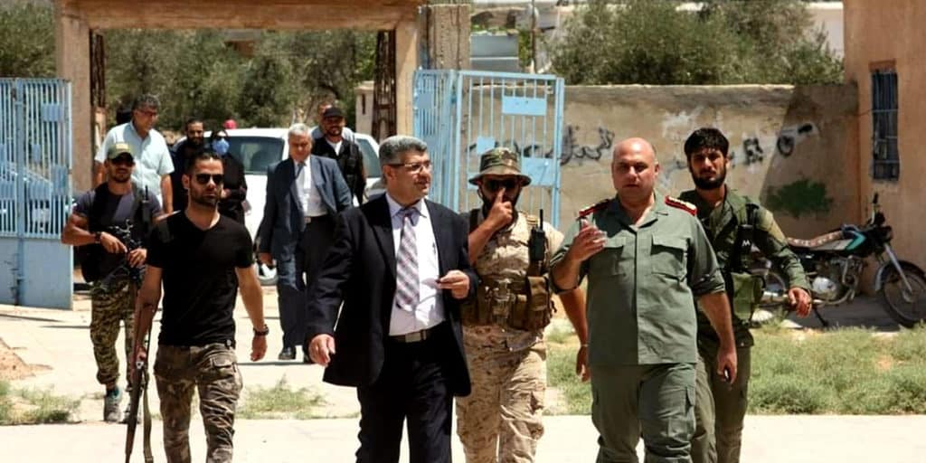 احد-المسؤولين-في-درعا-محاطا-بعناصر-مسلحة-في-مركز-انتخابي-للادلاء-بصوته