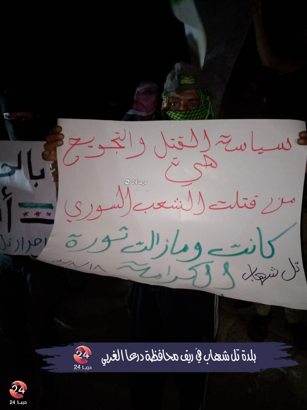 سياسة القتل والتجويع، لافتة في مظاهرة تل شهاب